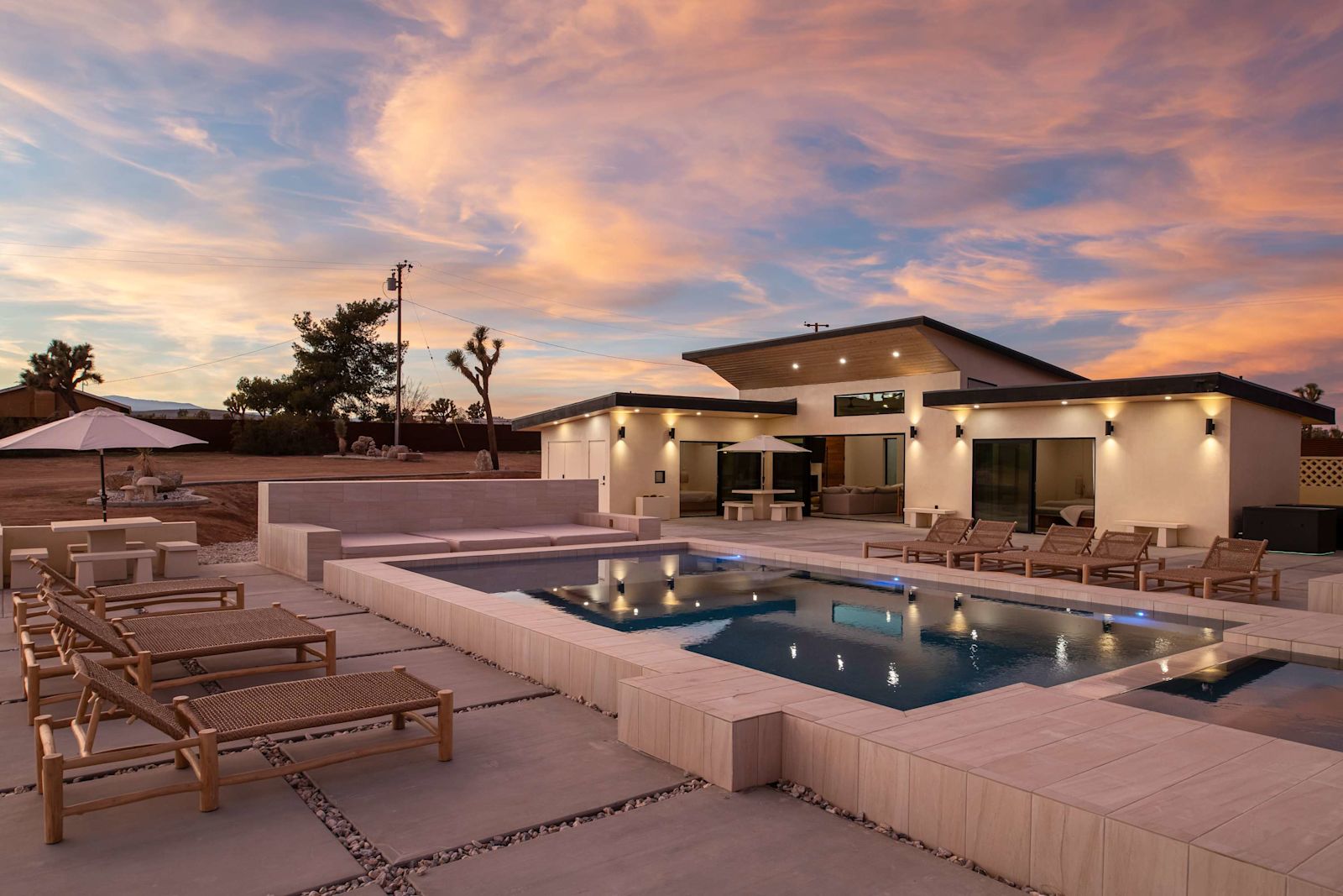 Heated pool and lounge deck at sunset with the Beachhouse behind