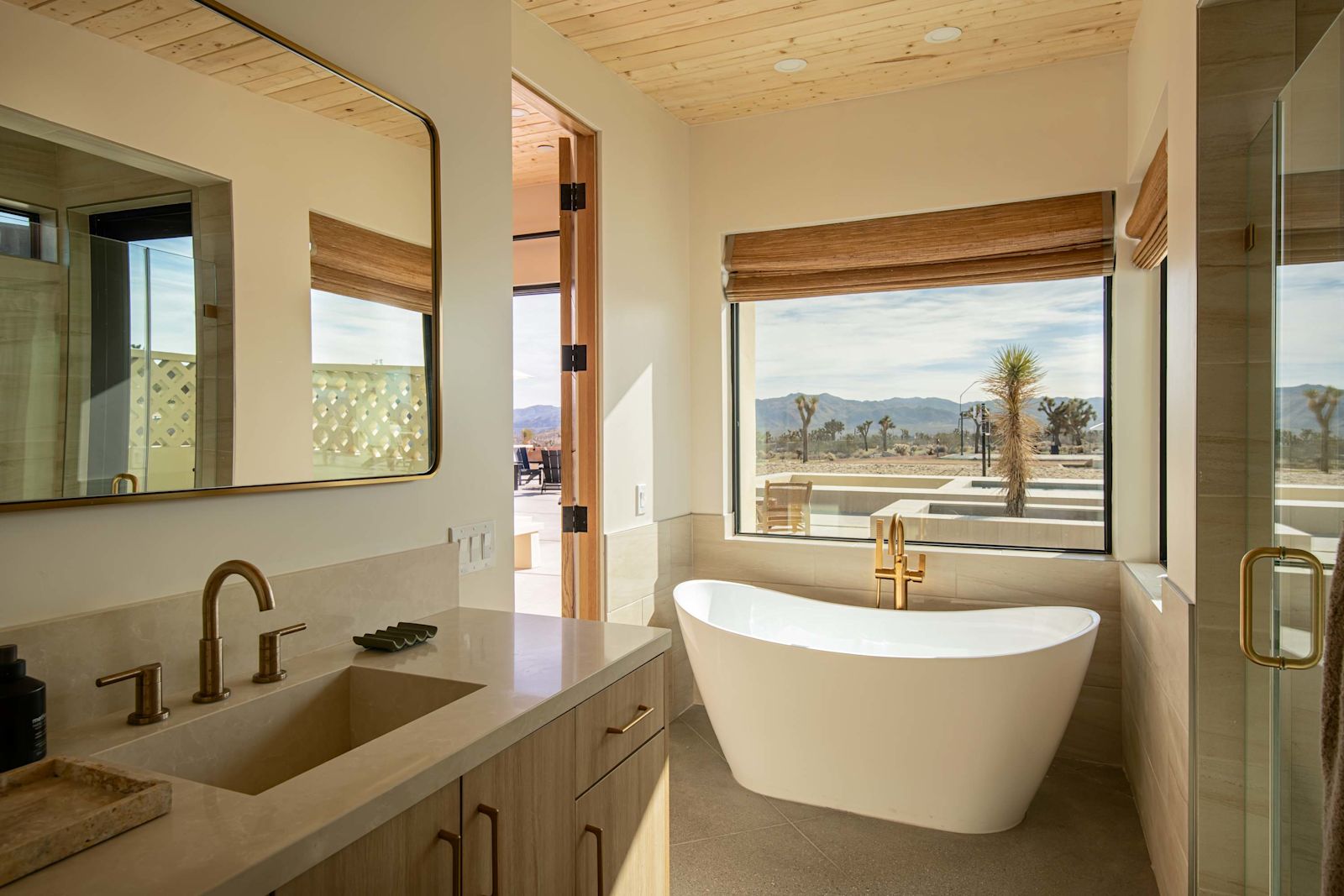Freestanding soaking tub beside a picture window with desert views