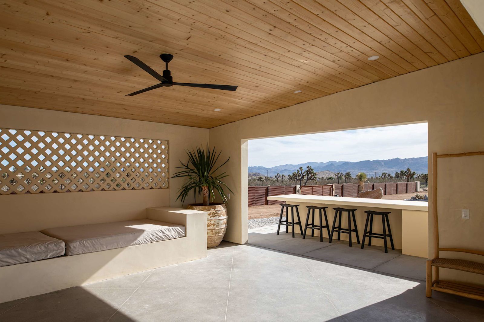 Shaded outdoor lounge and bar with lattice wall and desert views