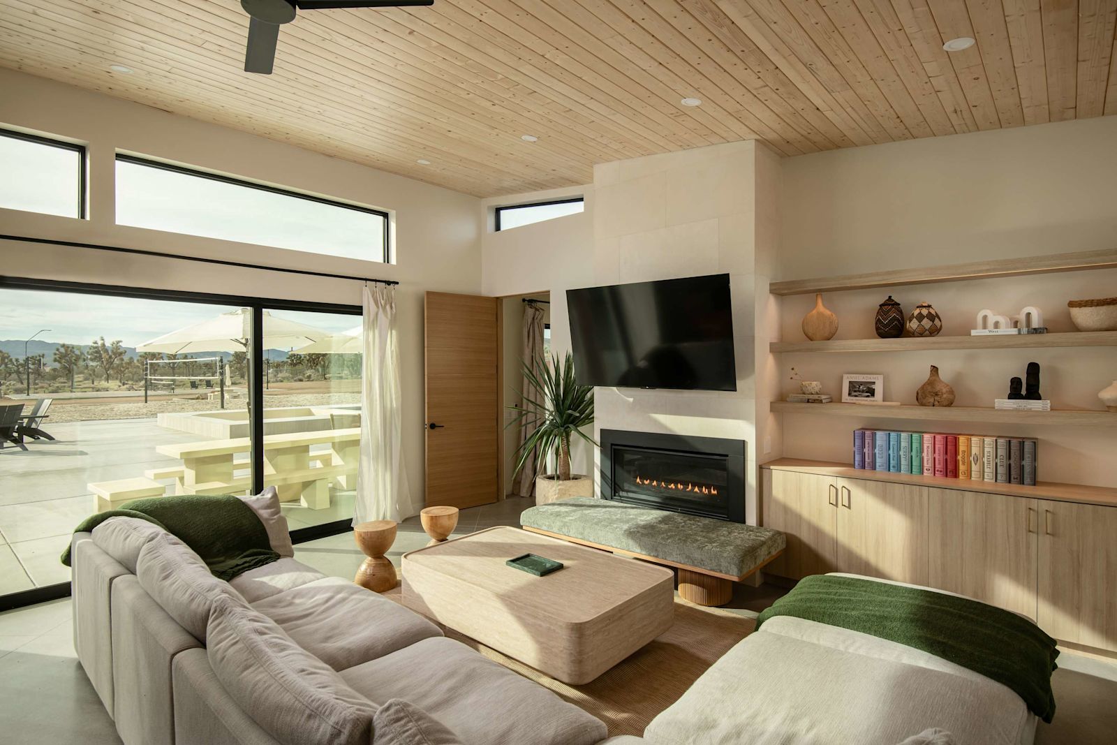 Open-plan living room with fireplace opening to the pool deck