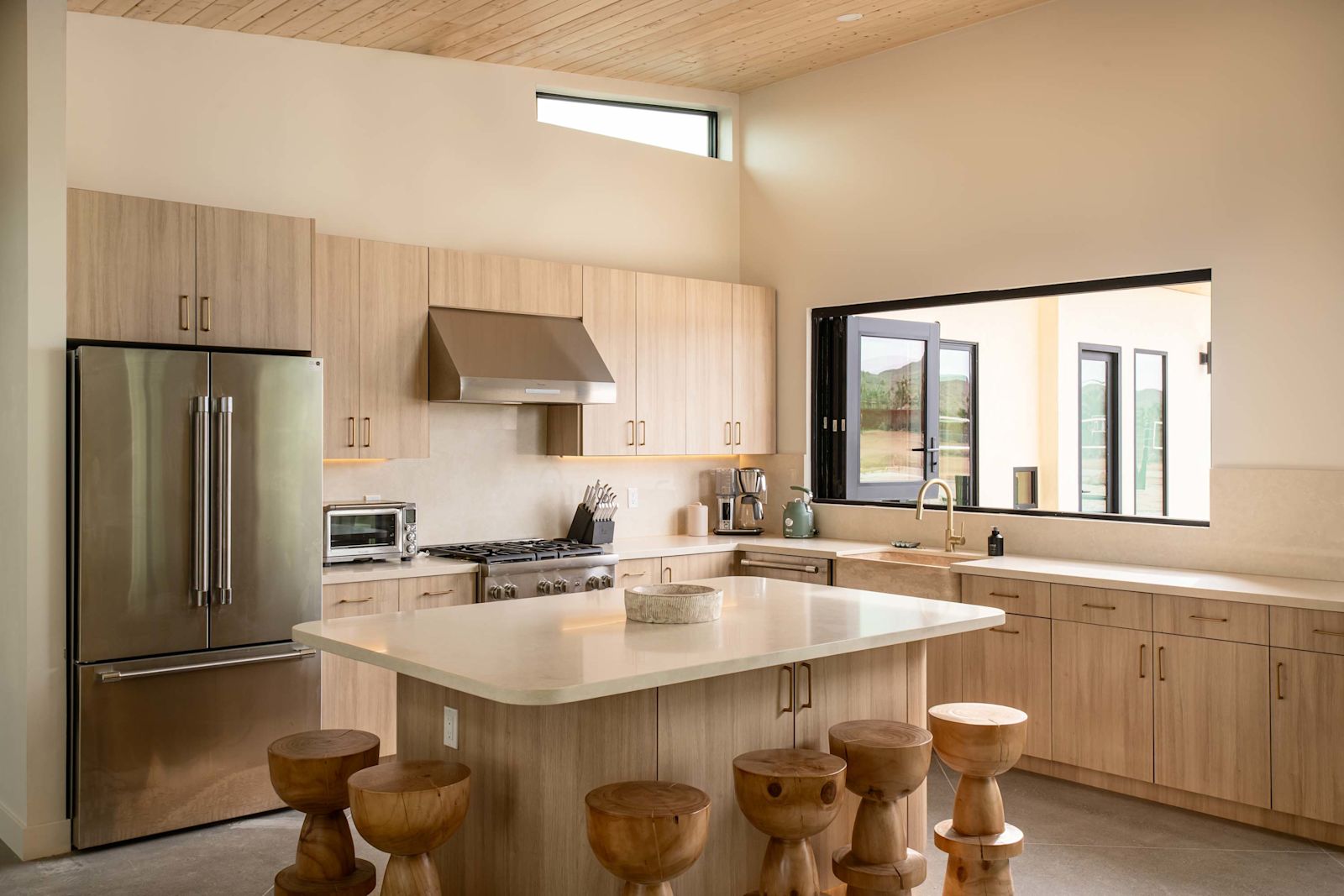 Chef's kitchen with island and sculptural wood stools