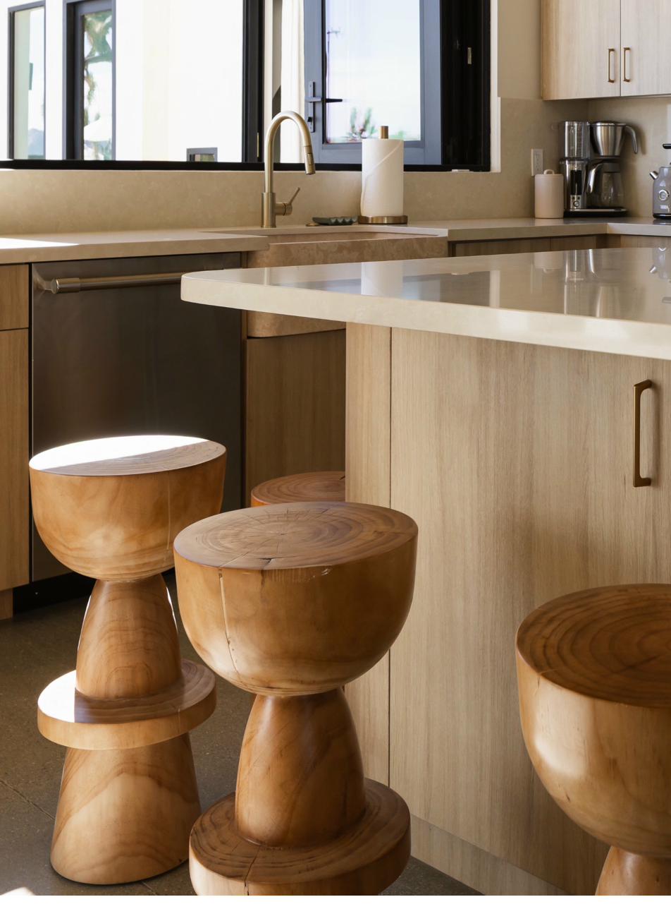 Kitchen with sculptural wood stools and quartz island