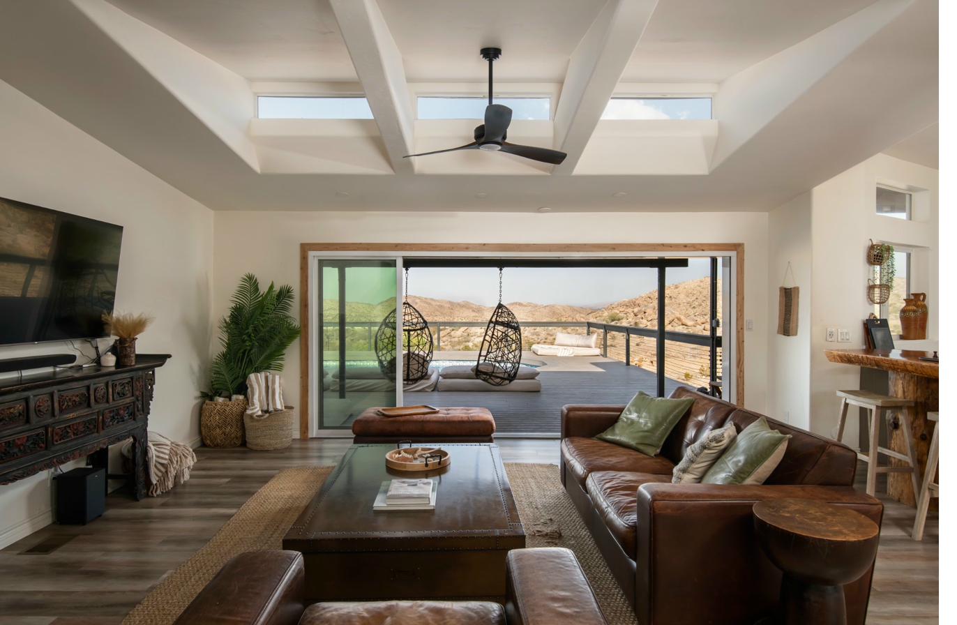 Living room opening to pool deck with canyon views