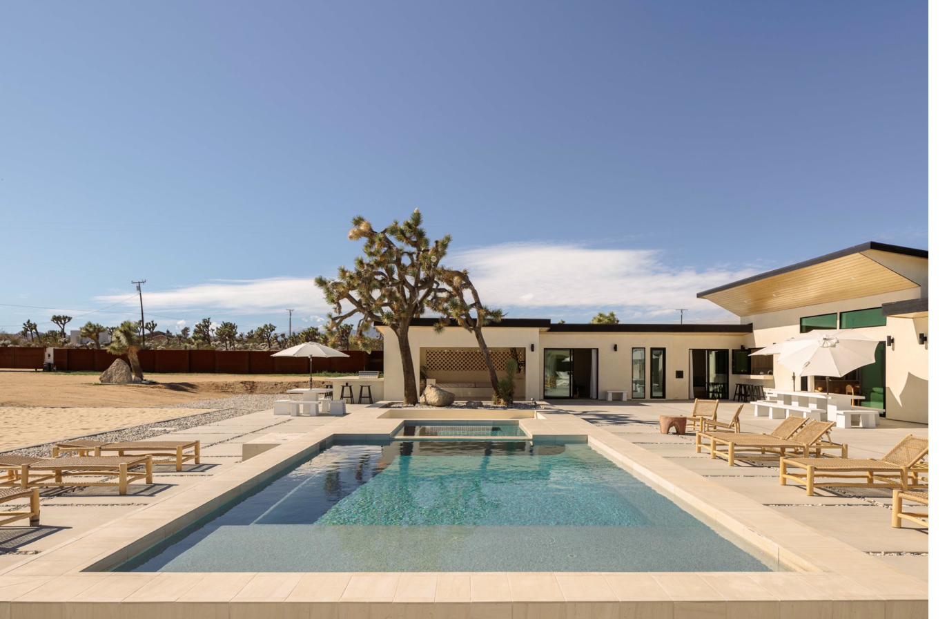 Crystal-blue pool with Joshua Tree and blue sky